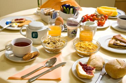 a table topped with plates of breakfast foods and drinks at Hotel Relais Agli Olivi in Lazise