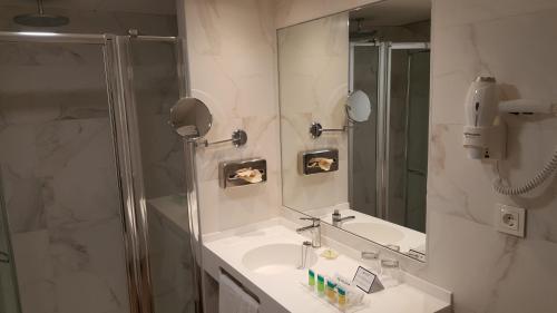 a bathroom with a shower and a sink and a mirror at Senator Barajas in Madrid