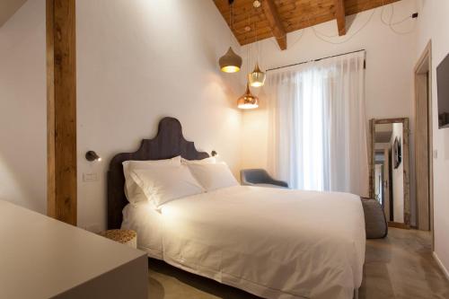 a bedroom with a white bed and a window at Terra di Gradara in Gradara