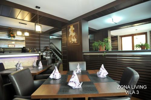 a restaurant with tables and chairs with napkins on them at Complex Cochet in Buşteni