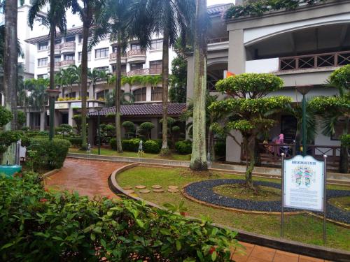 a park in front of a building with a sign at Costa Mahkota (Family Homestay) @ Mahkota Melaka in Melaka