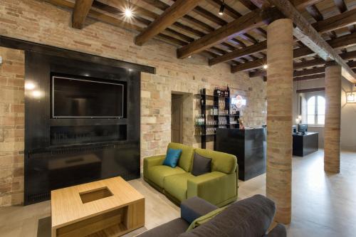a living room with a fireplace and a green chair at Terra di Gradara in Gradara