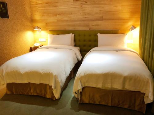 two beds sitting next to each other in a room at Inhouse Hotel Taichung in Taichung