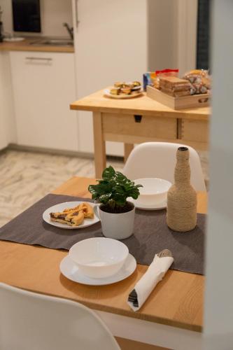 a table with plates of food and a plant on it at UP&B Rooms Catania in Mascalucia