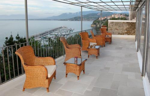 a row of wicker chairs and tables on a balcony at San Francesco Resort in Agropoli