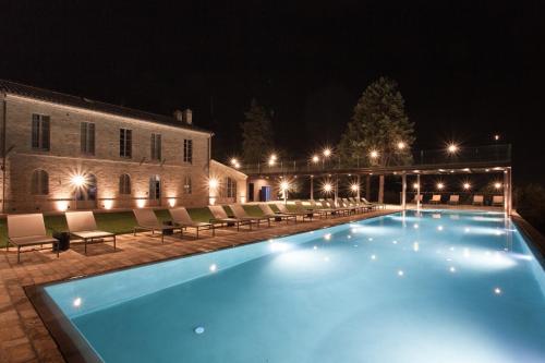 a large swimming pool in front of a building at night at Terra di Gradara in Gradara