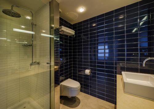 W wyłożonej niebieskimi kafelkami łazience znajduje się toaleta i umywalka. w obiekcie Absolute Hotel Limerick w mieście Limerick