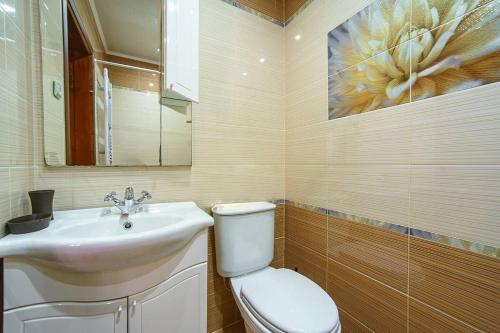 a bathroom with a white toilet and a sink at Villa U Tsymbora in Sinyak