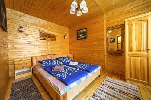 a bedroom with a bed in a wooden cabin at Villa U Tsymbora in Sinyak