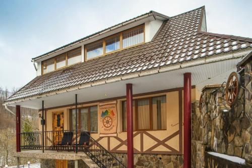 a house with a balcony and a stone wall at Villa U Tsymbora in Sinyak