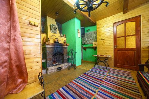 a living room with a fireplace and wooden walls at Villa U Tsymbora in Sinyak