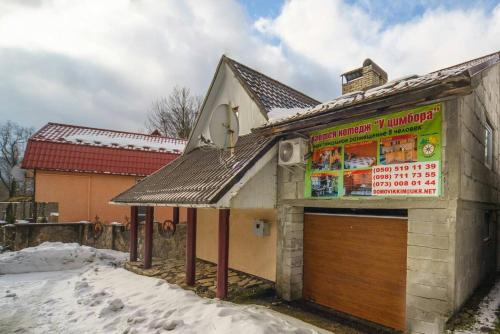 a building with a sign on it in the snow at Villa U Tsymbora in Sinyak