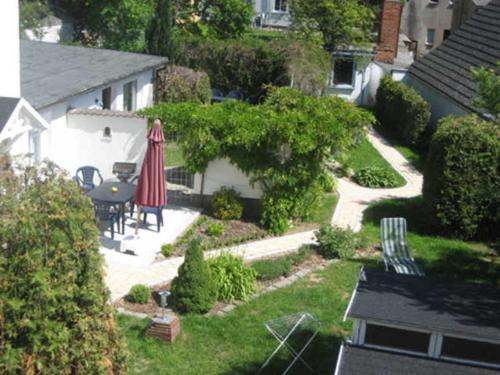 a garden with a table and chairs and an umbrella at Pension Waldrose in Ostseebad Sellin