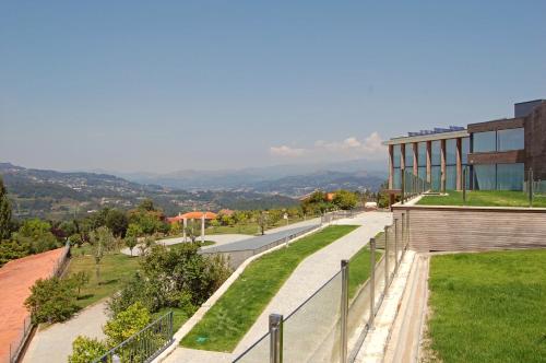a view of a building with a fence and grass at Tempus Hotel & Spa in Ponte da Barca