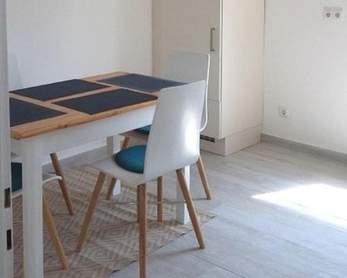 - une table à manger avec 2 chaises blanches et une table dans l'établissement Ferienwohnung Hofgarten, à Ansbach