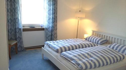 two beds in a hotel room with a window at Ferienwohnung Hofgarten in Ansbach