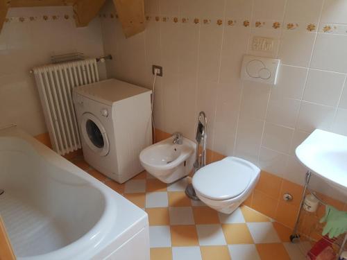 een badkamer met een toilet, een wastafel en een bad bij Antico Maso in Lavarone