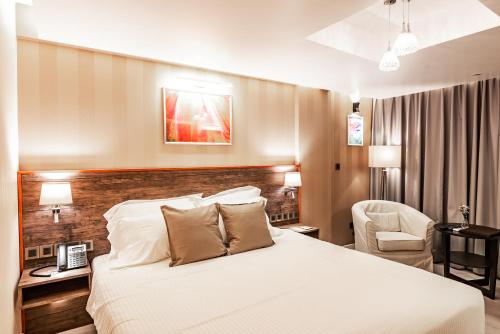 um quarto de hotel com uma cama e uma cadeira em Amina Residency em Malé