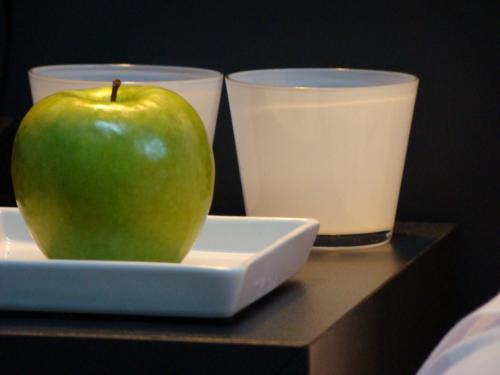 a green apple sitting on top of a white plate at Hotel Forum Evolución in Burgos