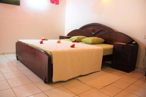 a bedroom with a large bed with a wooden headboard at Villa Ranmenika in Ahungalla
