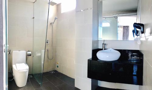 
a bathroom with a toilet, sink, and shower at New Sun Hotel in Nha Trang
