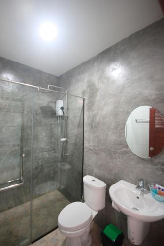 a bathroom with a shower and a toilet and a sink at The Aireen Hotel in Ao Nang Beach