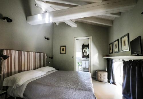 Corte Merighi Charming Rooms في فيرونا: غرفة نوم بسرير في غرفة ذات سقف
