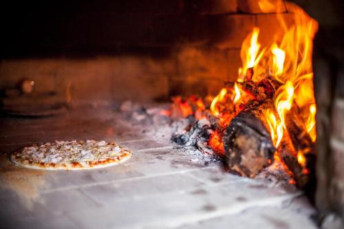 Dos pizzas están cocinando en un horno de ladrillo en Capricorn Beach Cottages, en Pangani