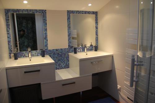 a bathroom with two sinks and a mirror at La Belle Vie Capbreton in Capbreton