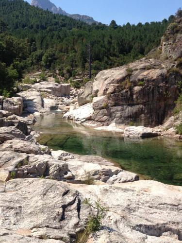 a body of water on a rocky hillside at Hotel Olmuccio in Sainte-Lucie de Porto-Vecchio