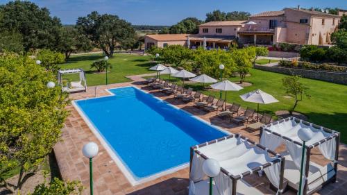 uma vista superior para uma piscina com cadeiras e guarda-sóis em Finca Son Roig by Valentin em Porreres