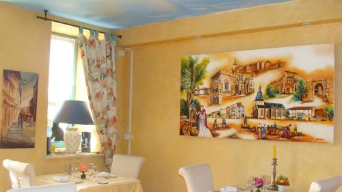 a dining room with a painting on the wall at Auberge de Marville in Marville