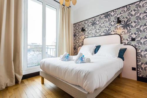 um quarto com uma cama com dois bichos de peluche em Joie Paris Opéra - Gare St Lazare em Paris