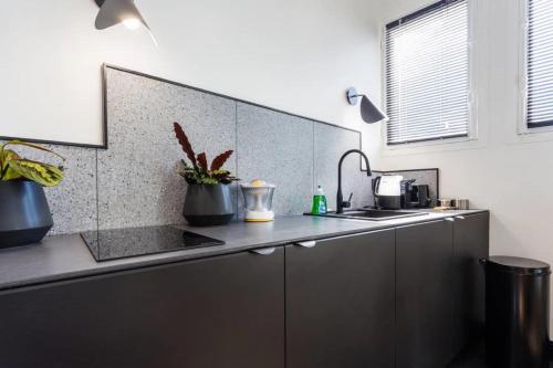 une cuisine avec un évier et un plan de travail dans l'établissement Joie Paris Opéra - Gare St Lazare, à Paris