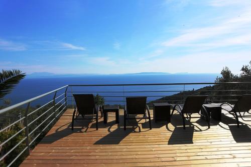 a deck with chairs and a table on top of the ocean at Dio Guesthouses in Leonidion