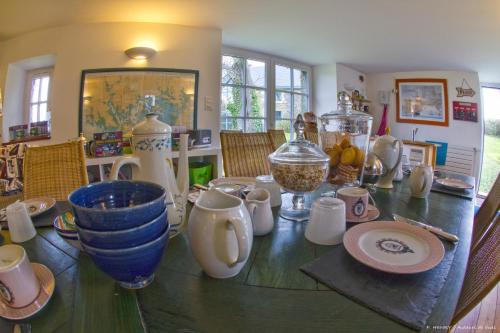 a table with a bunch of vases and plates on it at Ar Couette in Le Bono