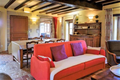 un salon avec un canapé rouge et une table dans l'établissement Domaine La Carrière, à Toulon-sur-Allier