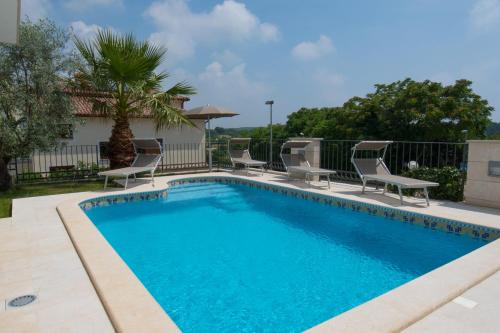 a swimming pool with chaise lounge chairs around it at Deluxe Apartment with private Pool - 100m from the sea in Pula