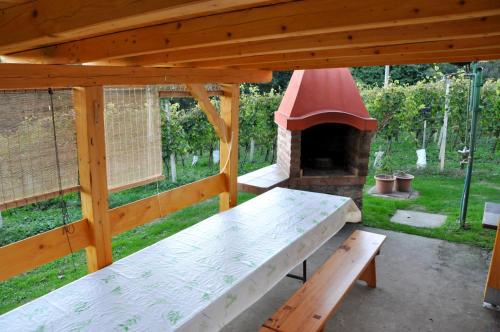 a wooden pavilion with a table and a brick oven at Apartman"KATJA" in Sveti Martin na Muri