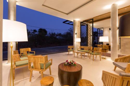 a living room with chairs and tables and a lamp at Akhyana Village in Jimbaran