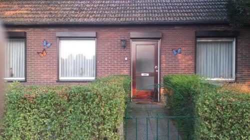 a red brick house with a door and a fence at appartement de Groote Peel in Nederweert