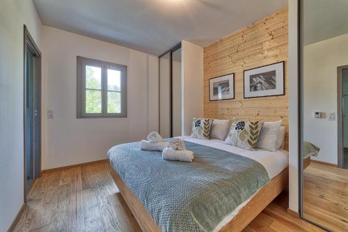 ein Schlafzimmer mit einem großen Bett mit zwei Teddybären darauf in der Unterkunft Base Camp: Residence Ferme de Montenvers in Chamonix-Mont-Blanc