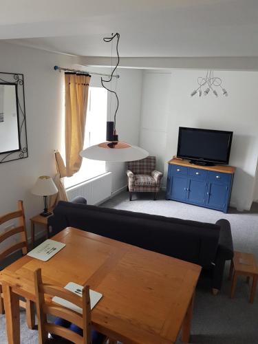 a living room with a couch and a table and a tv at Church View at Plover Cottage Lindley in Huddersfield