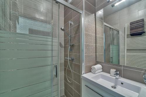 ein Bad mit einer Dusche, einem Waschbecken und einem Spiegel in der Unterkunft Base Camp: Residence Ferme de Montenvers in Chamonix-Mont-Blanc