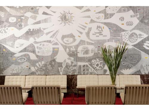 a room with chairs and a wall with a mural at Hotel Aurora in Lido di Jesolo