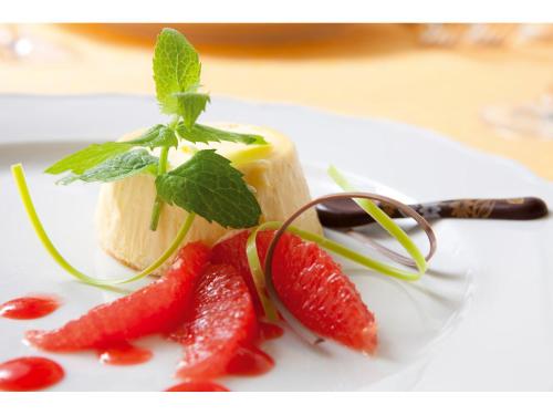 a piece of cheese with strawberries on a white plate at Hotel Aurora in Lido di Jesolo