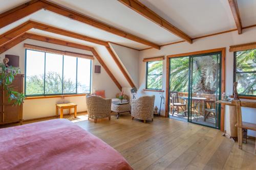 a bedroom with a bed and a table and chairs at Lézard Bleu Guest House in Cape Town