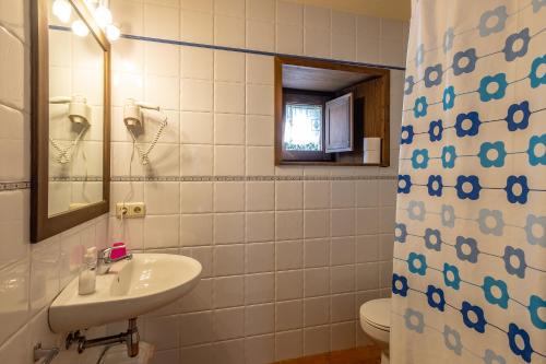 a bathroom with a sink and a toilet and a mirror at Torre Gelbert in Puigcerdà