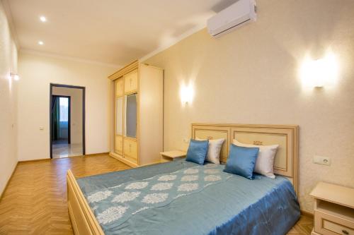 ムィコラーイウにあるLuxury apartmentsのベッドルーム(青い枕の大型ベッド1台付)
