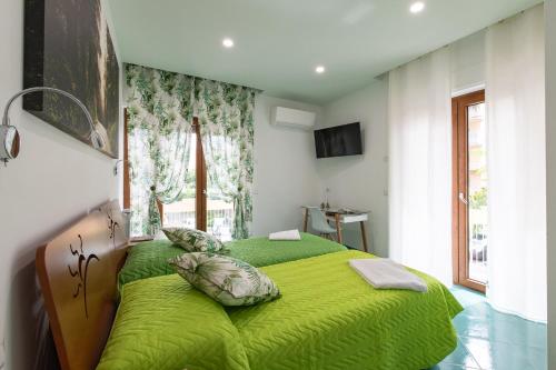 un letto verde in una stanza con finestra di Madimà a Sorrento